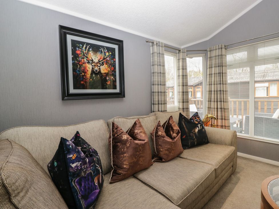 A living room with a couch and wall art at 32 Grasmere, White Cross Bay near Windermere