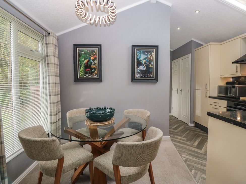 A dining room with a circular table and chairs at 32 Grasmere, White Cross Bay near Windermere
