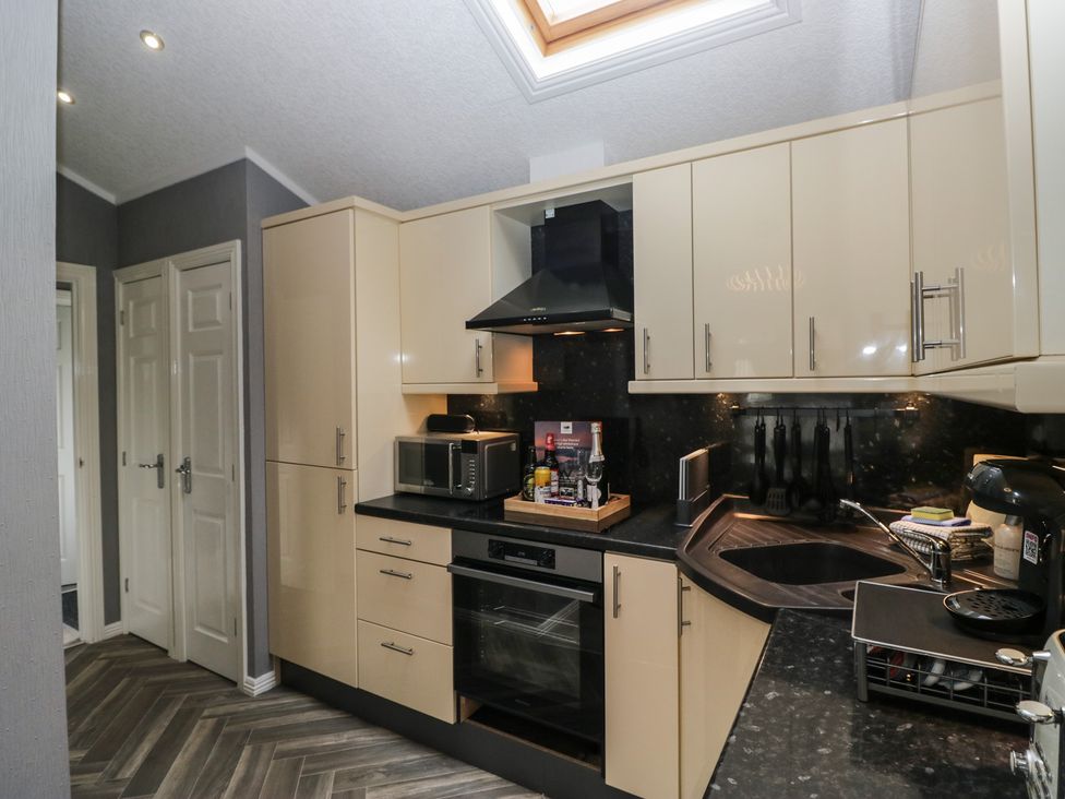 A kitchen with appliances and cabinets at 32 Grasmere, White Cross Bay near Windermere