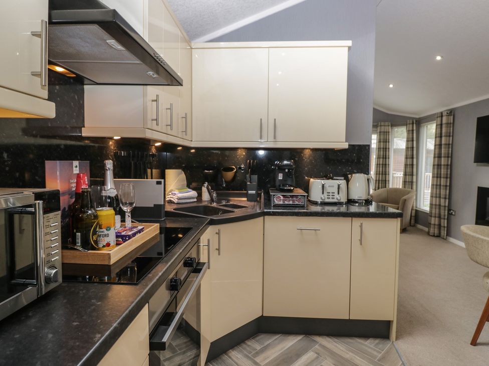 A kitchen with appliances and utensils at 32 Grasmere, White Cross Bay near Windermere