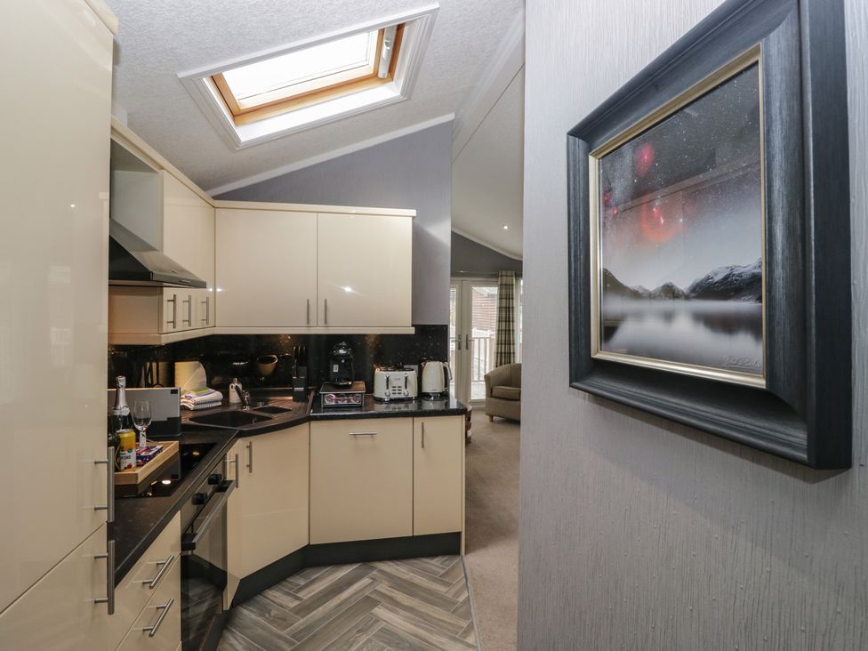 A kitchen with cabinets and appliances at 32 Grasmere, White Cross Bay near Windermere