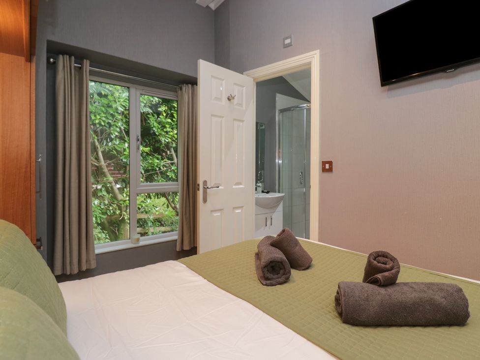 A bedroom with bed and towels at 32 Grasmere, White Cross Bay near Windermere