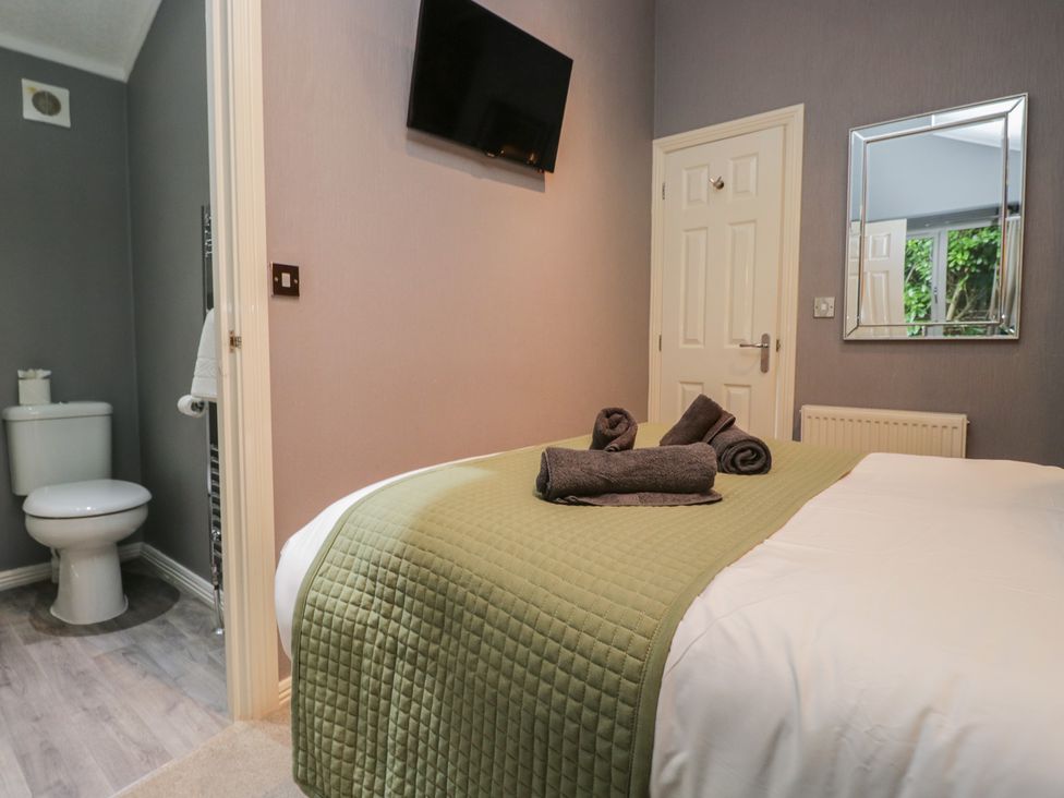 A bedroom with a double bed and en-suite toilet at 32 Grasmere, White Cross Bay near Windermere
