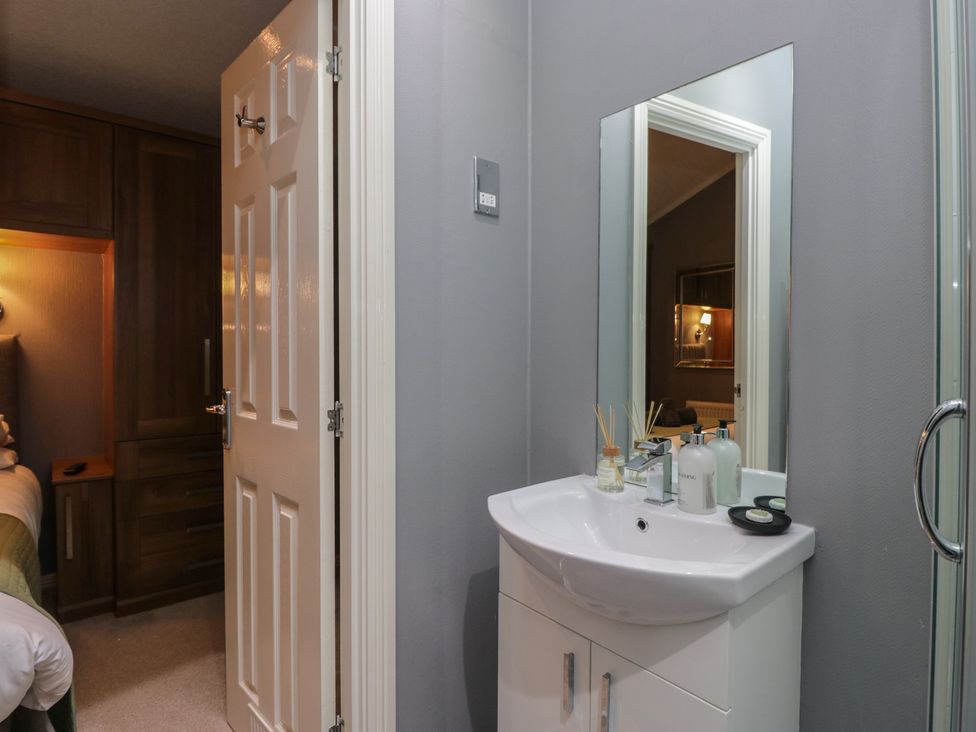 A bathroom featuring a sink and mirror at 32 Grasmere, White Cross Bay near Windermere
