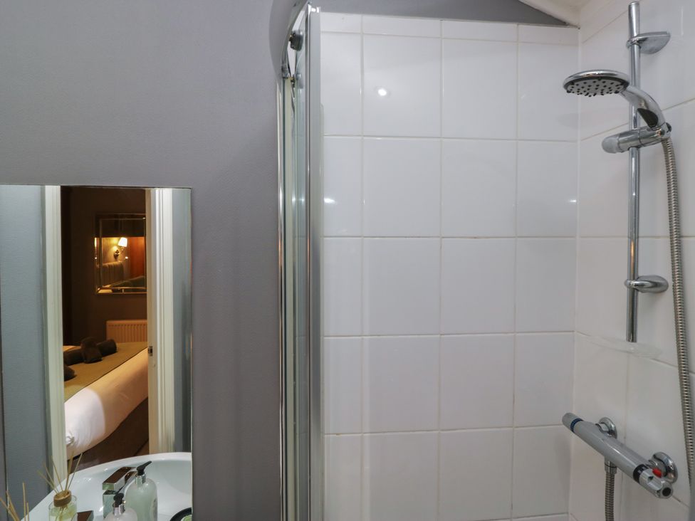 A shower with a mirror and sink at 32 Grasmere, White Cross Bay near Windermere