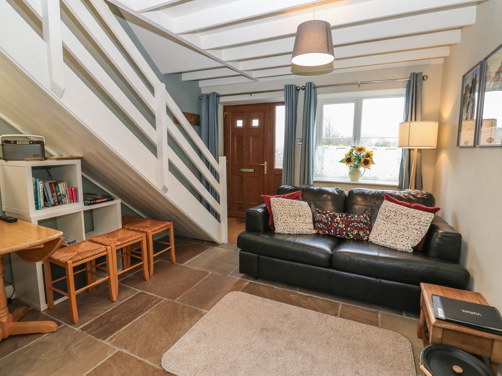 A living room with a sofa and bookcase at Tyg Cottage in Ripon