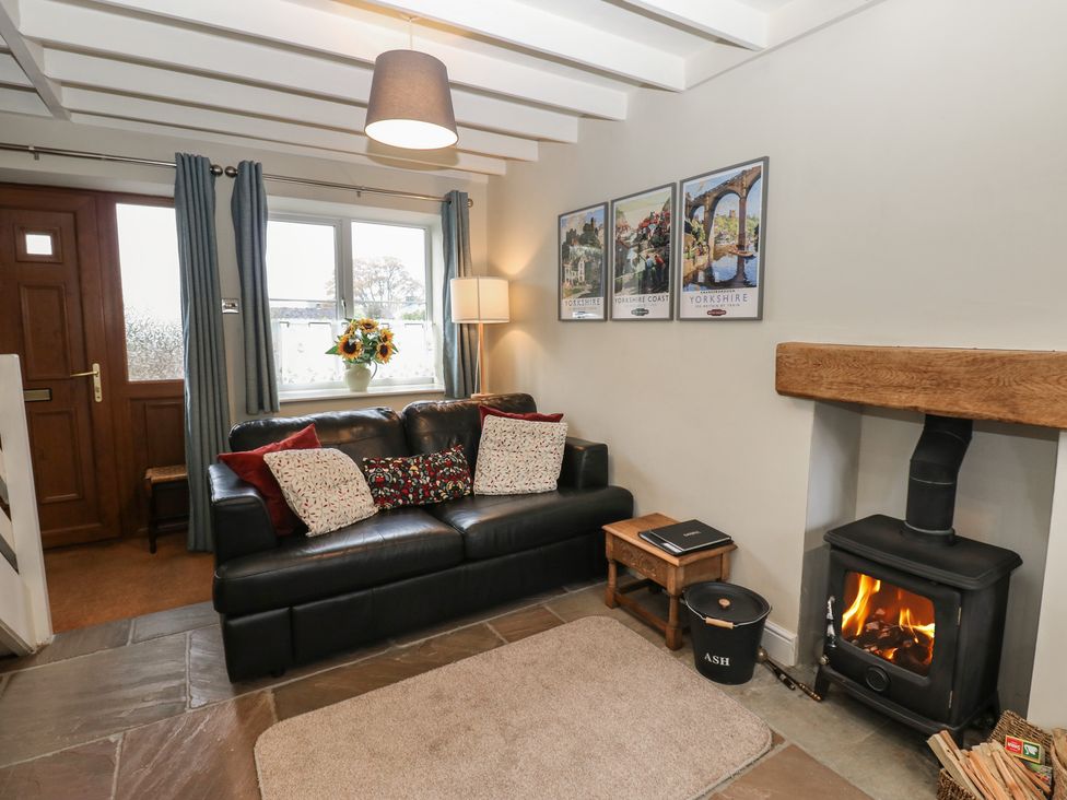 A living room with a sofa and a fireplace at Tyg Cottage in Ripon