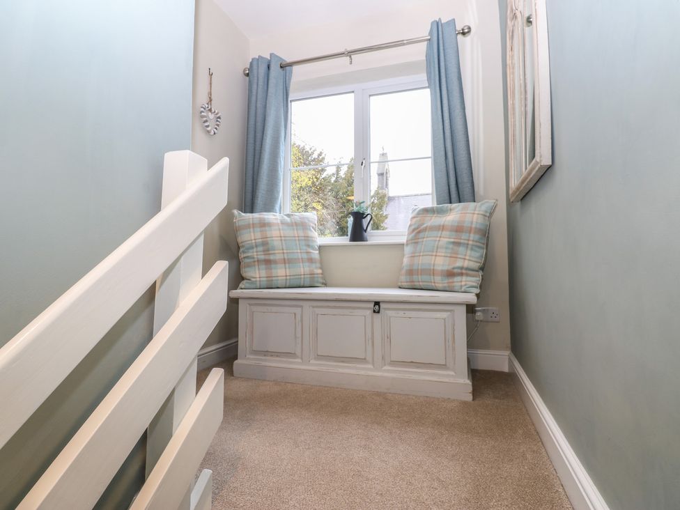 A hallway with a staircase and a window seat at Tyg Cottage in Ripon