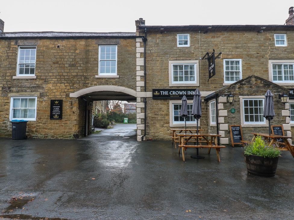 An outdoor area with seating and a sign at The Crown Inn in Ripon