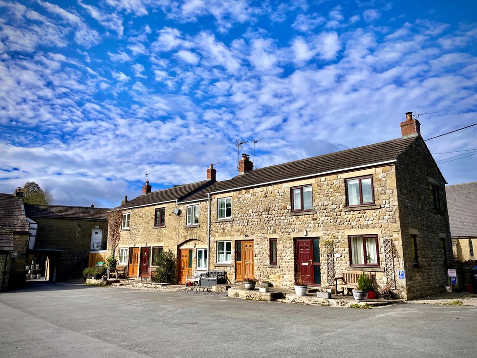 Exterior view of stone houses with doors and windows at Tyg Cottage Masham