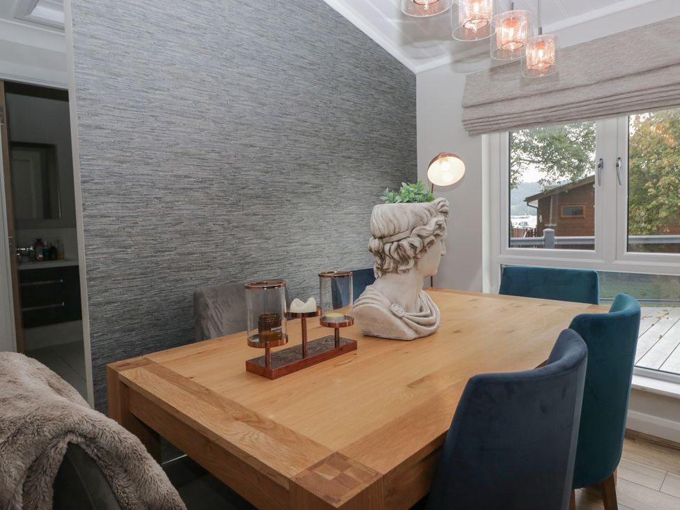 A dining room with a wooden table and chairs at 7 Lake View in Windermere