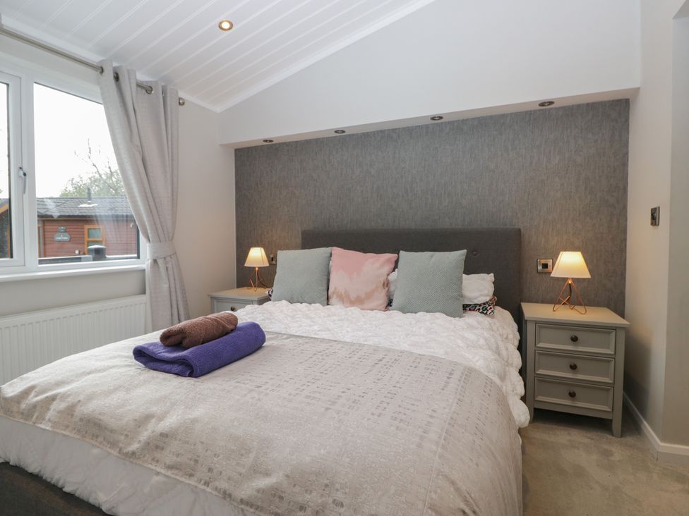 A bedroom with a bed and bedside table at 7 Lake View in Windermere