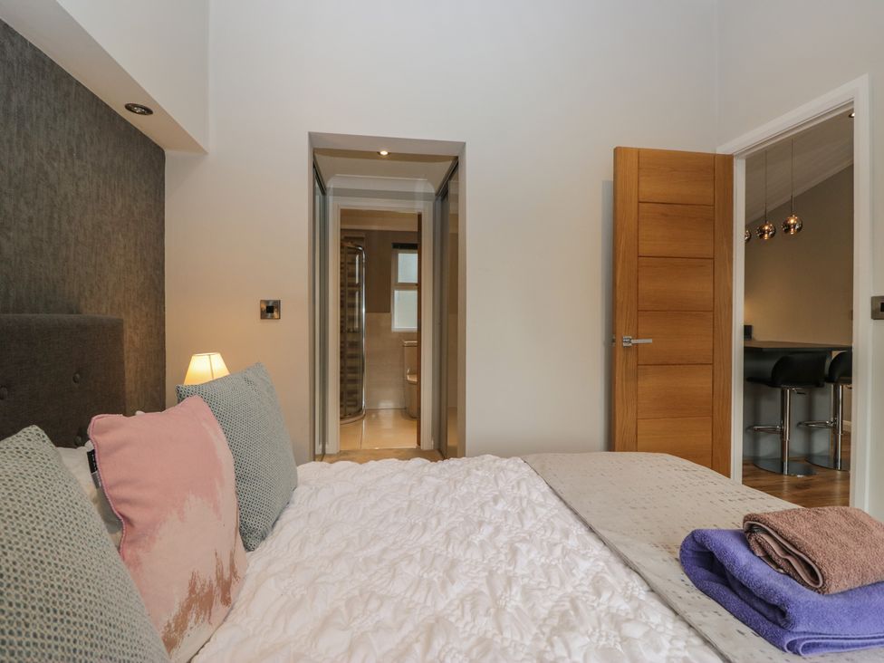 A bedroom with a bed and adjoining bathroom at 7 Lake View in Windermere