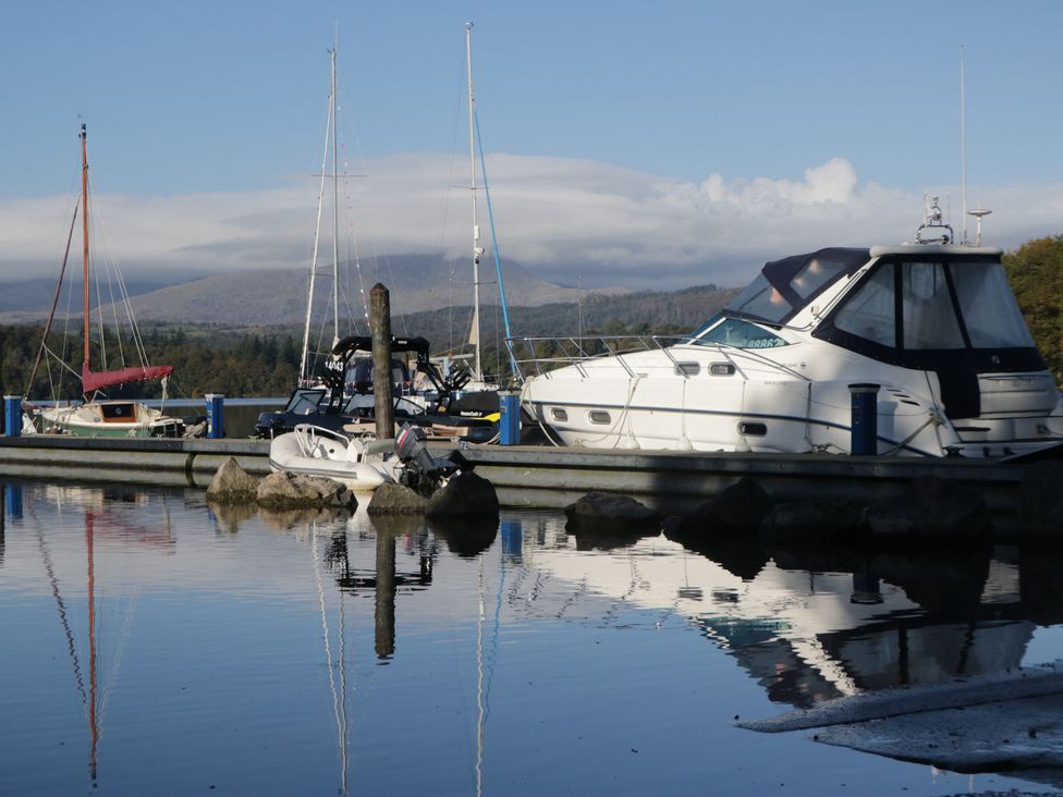 A dock with boats reflected in water at 7 Lake View in Windermere