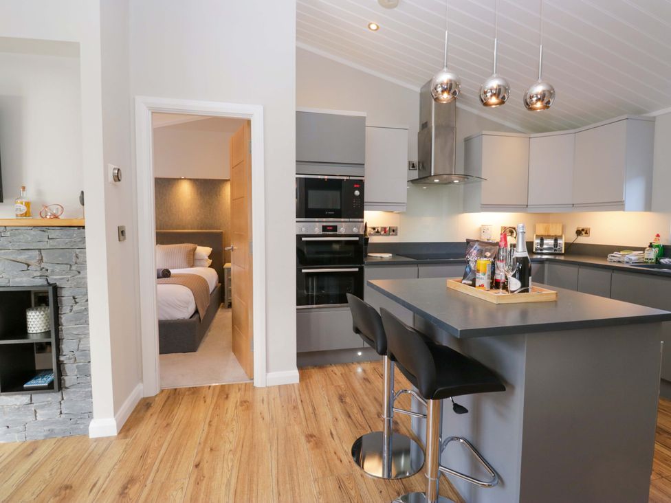 A kitchen with cabinets and bar stools at 7 Lake View, Lake View 7, White Cross Bay near Windermere