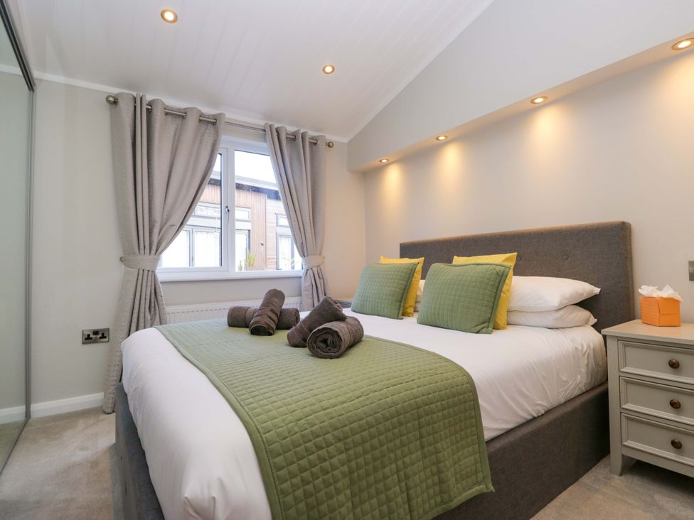 A bedroom with a bed and a bedside table at 7 Lake View, White Cross Bay near Windermere