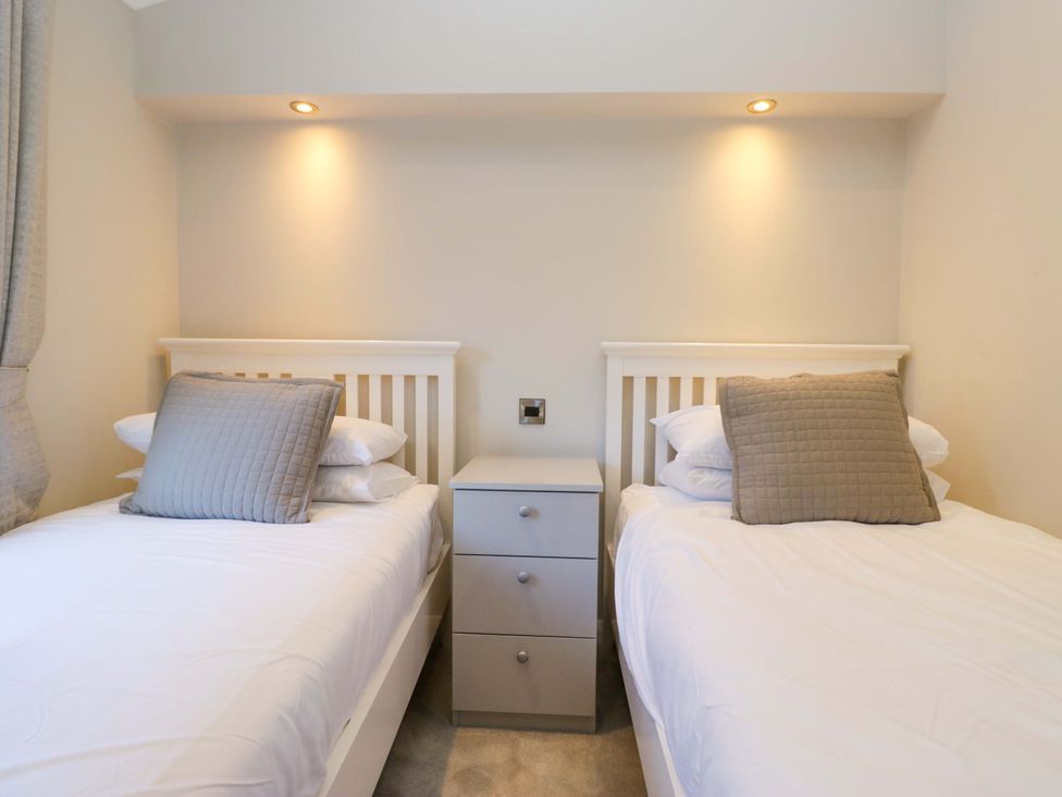 A bedroom with two beds and a nightstand at 7 Lake View, Lake View 7, White Cross Bay near Windermere