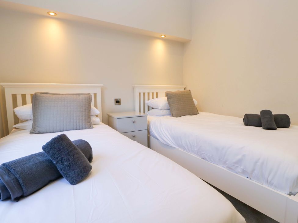 A bedroom with two beds and a nightstand at 7 Lake View, Lake View 7, White Cross Bay near Windermere