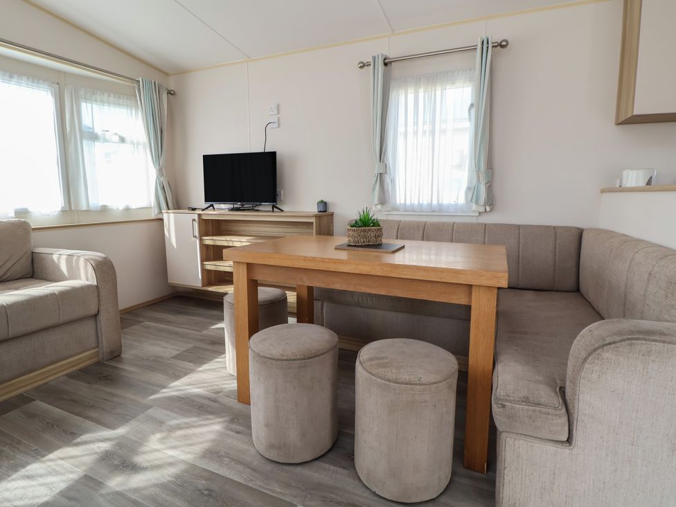 A living room with a television and table at E10 Static Caravan in Rhyl