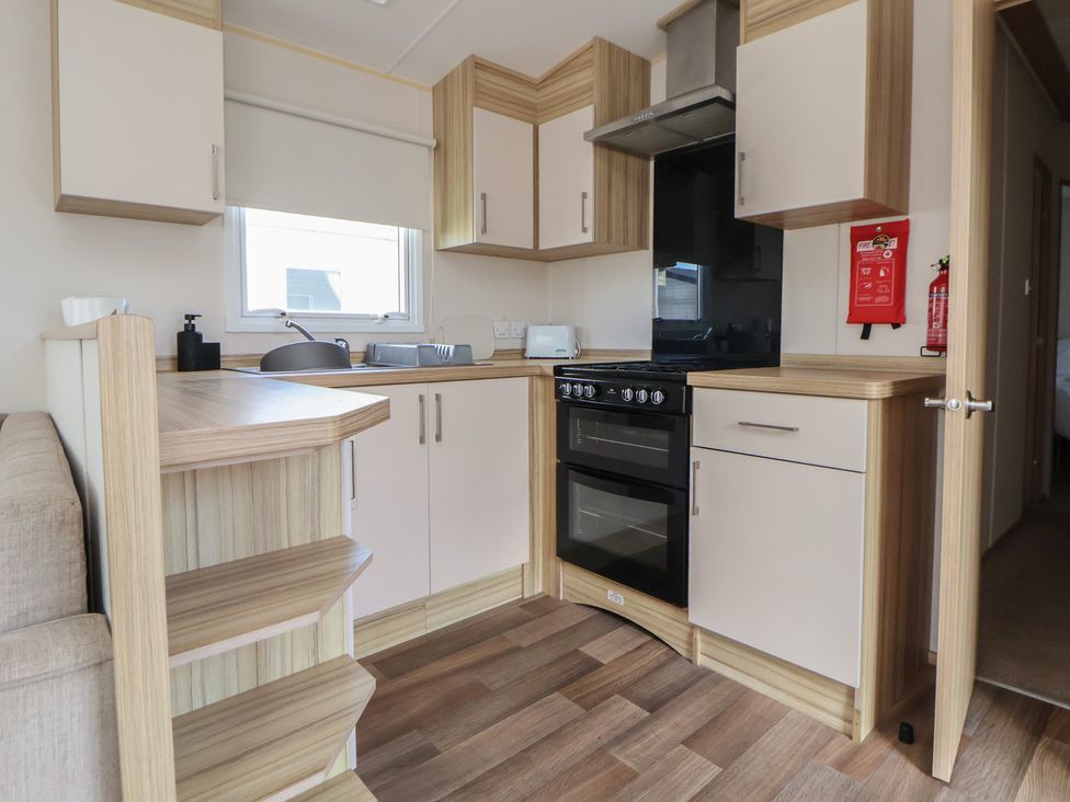 A kitchen with cabinets and appliances at E10 Static Caravan Rhyl