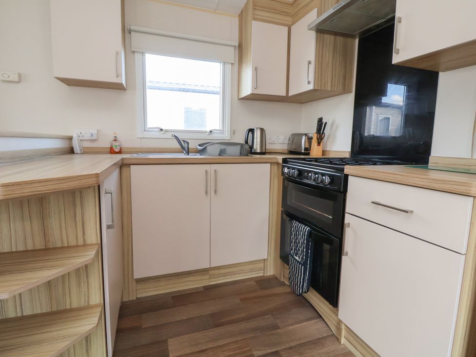 A kitchen with a stove and sink at A5 Static Caravan in Rhyl