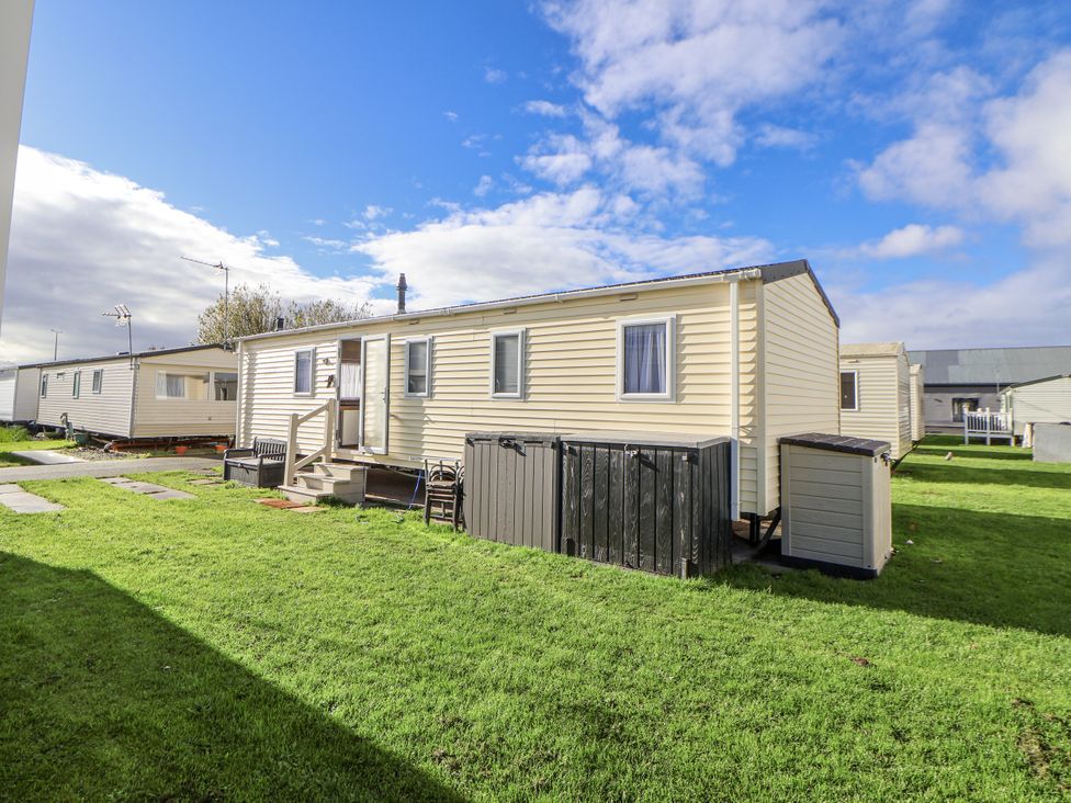 A mobile home with a garden and steps at Chappie's Caravan - Rhyl