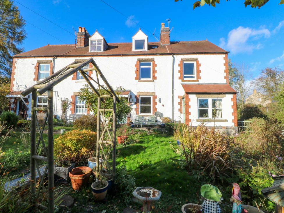 A house with a garden and archway at Pineapple Cottage