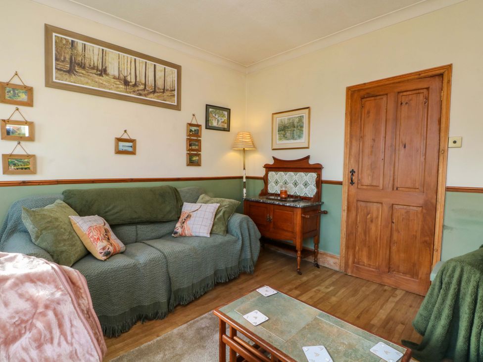 A living room with a sofa and coffee table at Pineapple Cottage