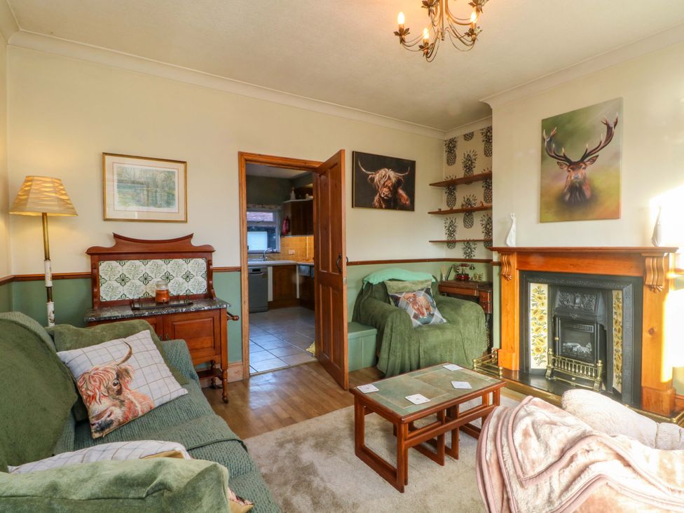 A living room with a sofa and fireplace at Pineapple Cottage 