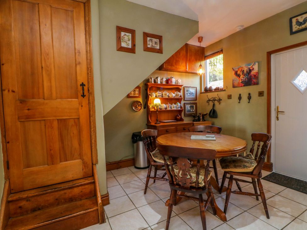 A dining room with a wooden table and chairs at Pineapple Cottage
