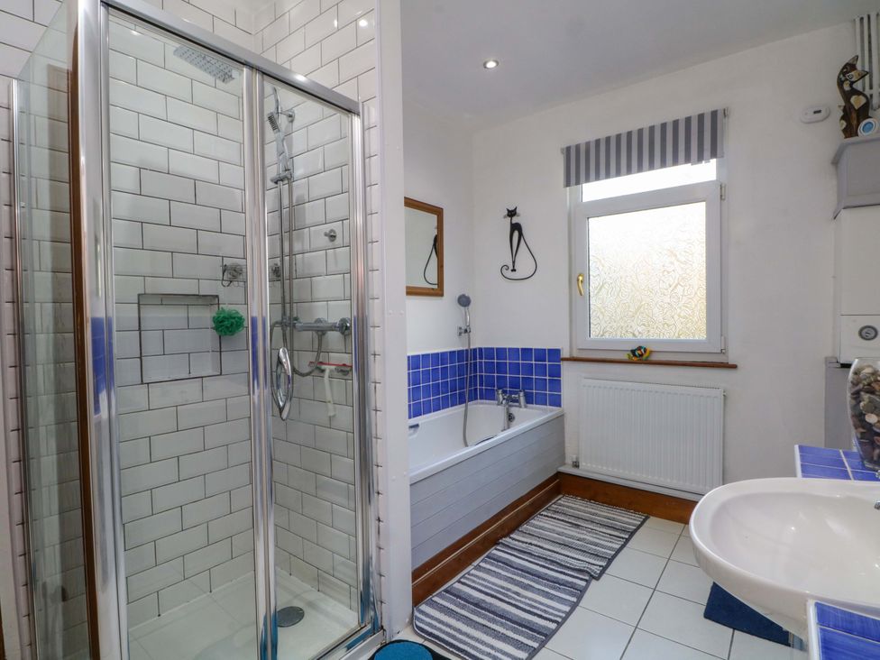 A bathroom with a shower and bathtub at Pineapple Cottage