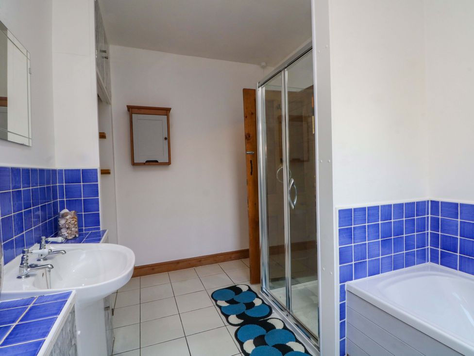 A bathroom with a sink, shower, and bathtub at Pineapple Cottage