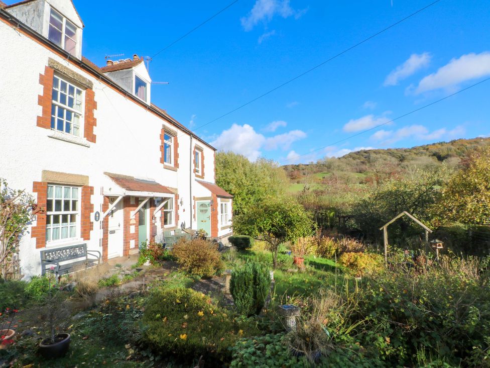 A house with a garden and trees at Pineapple Cottage