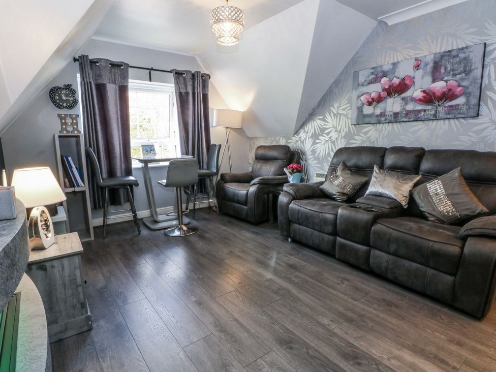 A living room with a sofa and a table at 24 Wilmslow Court in Wilmslow