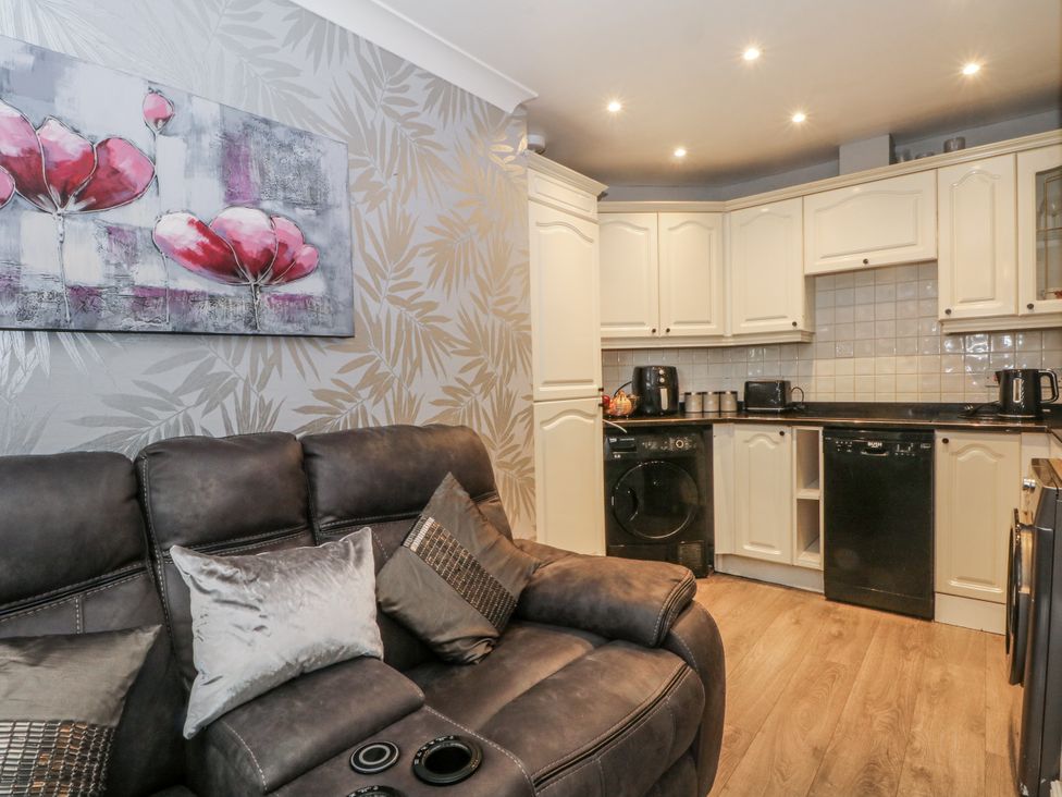 A kitchen with a sofa and appliances at 24 Wilmslow Court in Wilmslow