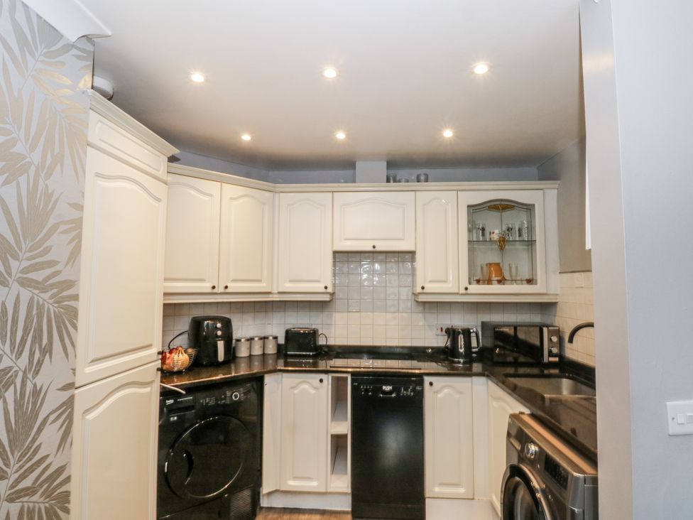 A kitchen with appliances and cabinets at 24 Wilmslow Court in Wilmslow