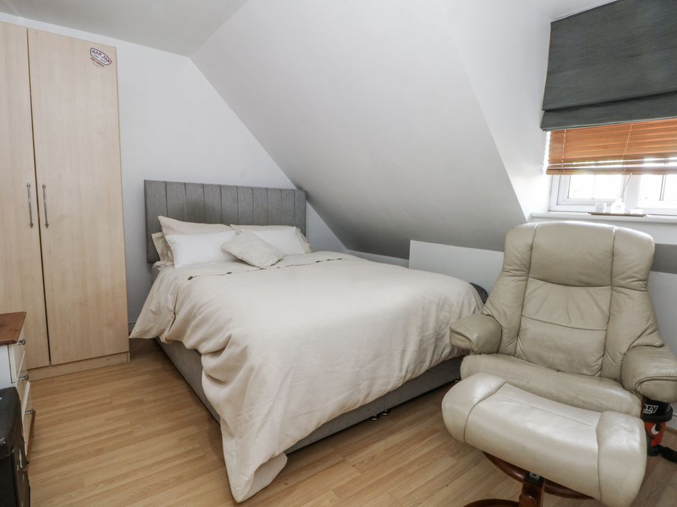 A bedroom with a bed and a wardrobe at 24 Wilmslow Court in Wilmslow