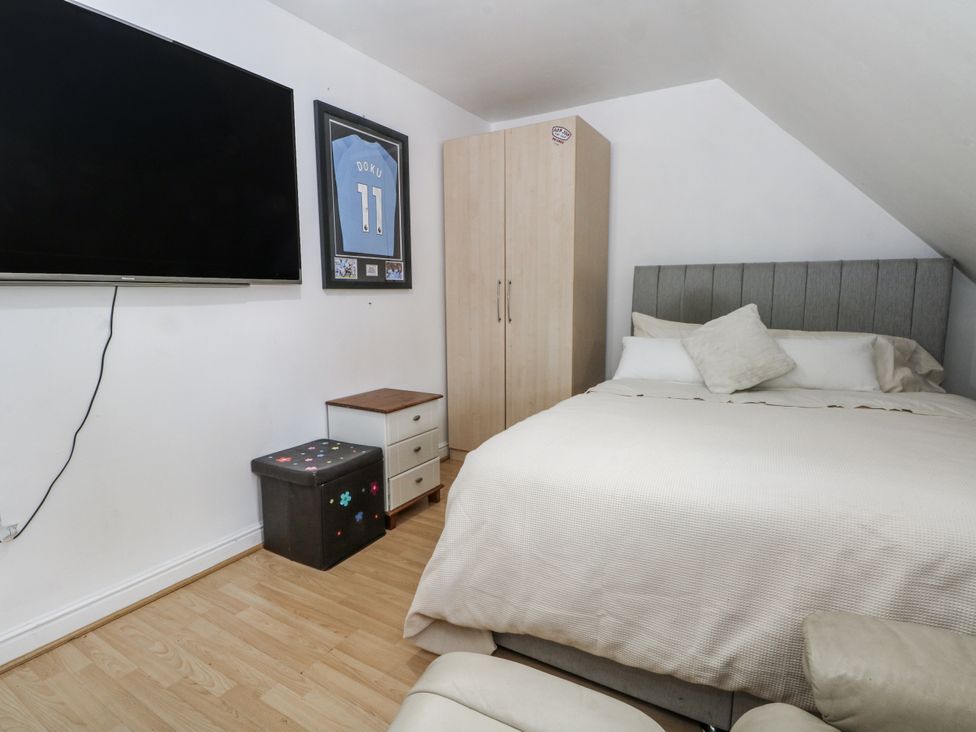 A bedroom with a bed, wardrobe, nightstand and television at 24 Wilmslow Court Wilmslow