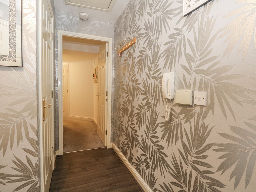 A hallway with doors and a telephone at 24 Wilmslow Court in Wilmslow