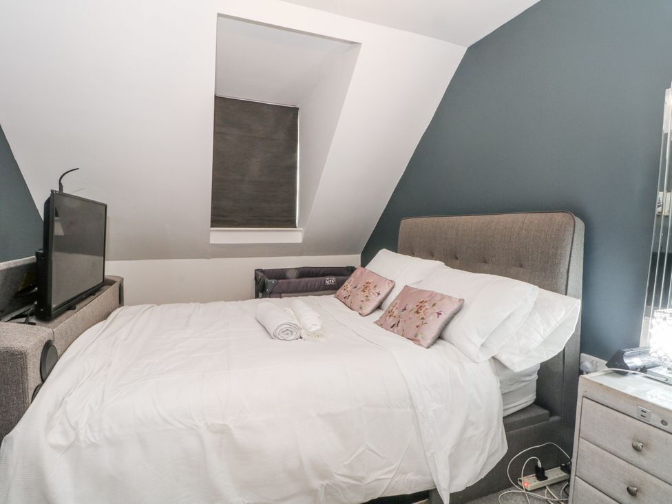A bedroom with a bed and television at 24 Wilmslow Court in Wilmslow