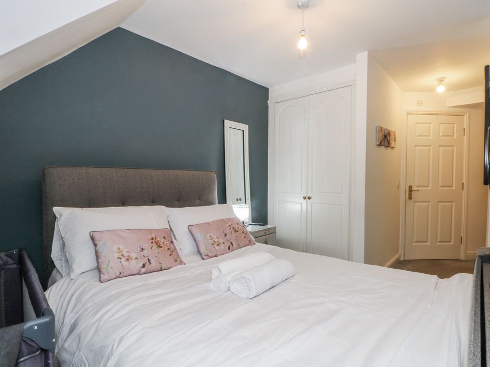 A bedroom with a bed and a mirror at 24 Wilmslow Court in Wilmslow