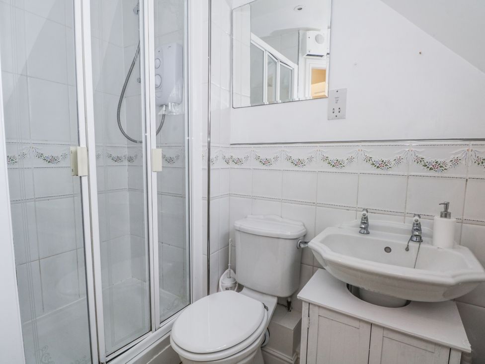 A bathroom with a shower, toilet, and sink at 24 Wilmslow Court, Wilmslow