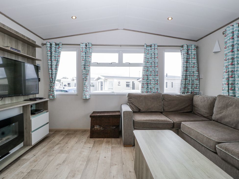 A living room with a sofa and TV unit at Caravan - 2 Bayside Watchet