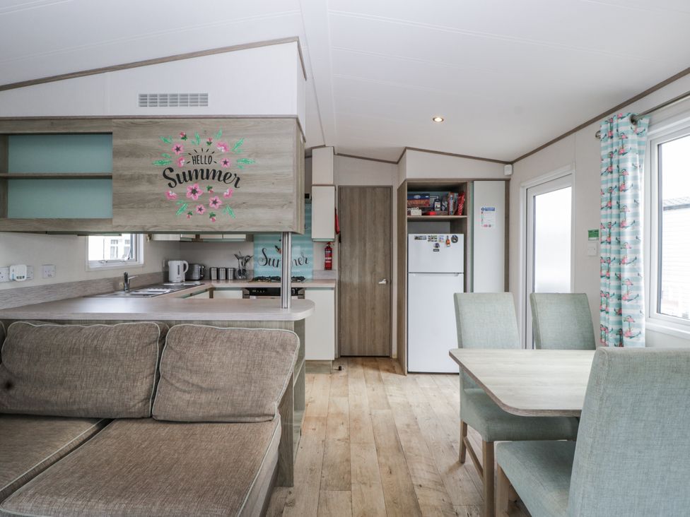 A kitchen with a sofa and dining table at Caravan - 2 Bayside Watchet
