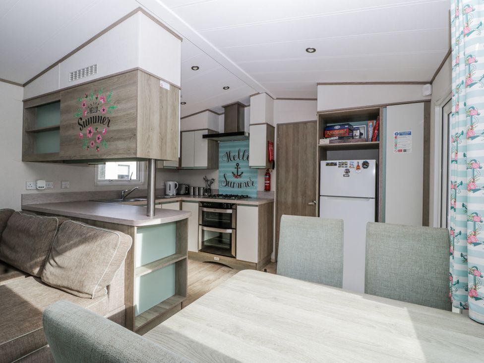 A kitchen with a seating area and appliances at Caravan - 2 Bayside Watchet