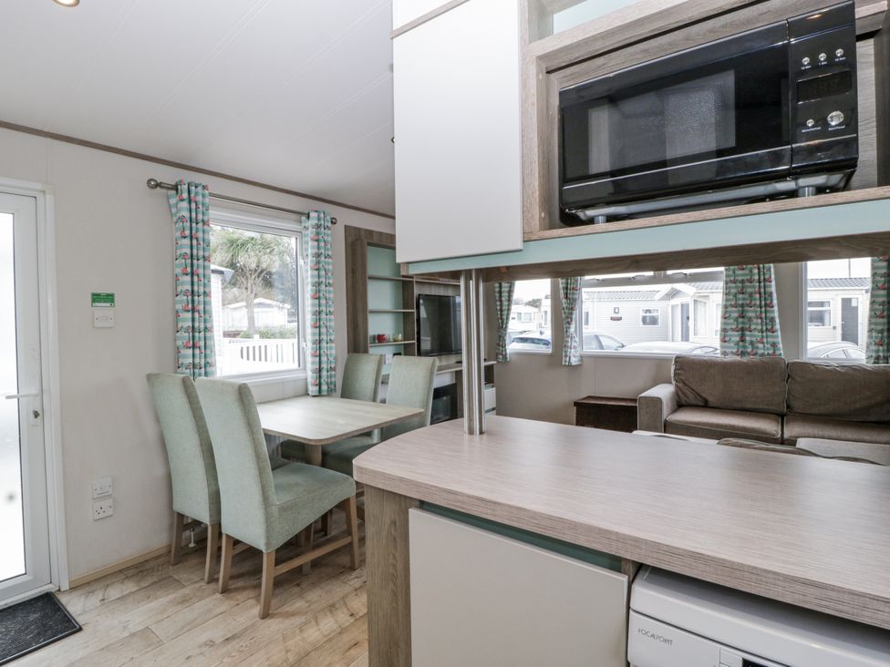A dining room with a table and chairs at Caravan - 2 Bayside in Watchet