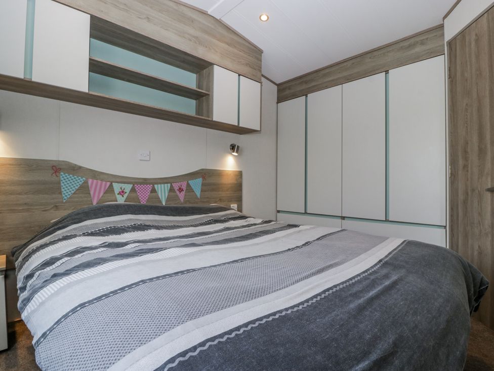 A bedroom with a bed and storage units at Caravan - 2 Bayside Watchet