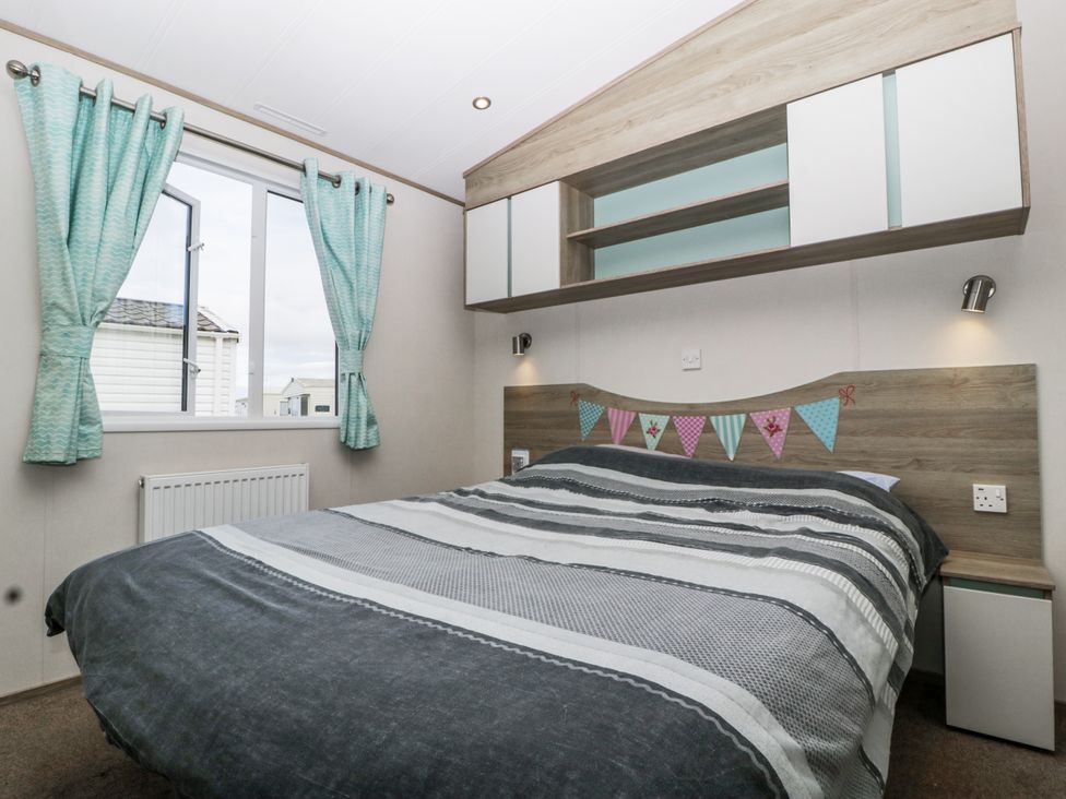 A bedroom with a bed and window at Caravan - 2 Bayside Watchet
