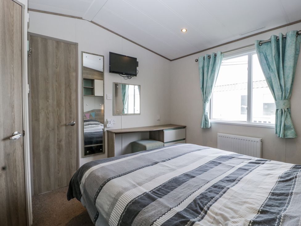 A bedroom with a bed and a desk at Caravan - 2 Bayside in Watchet
