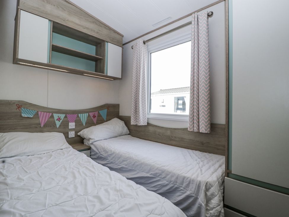 A bedroom with two beds and a window at Caravan - 2 Bayside in Watchet